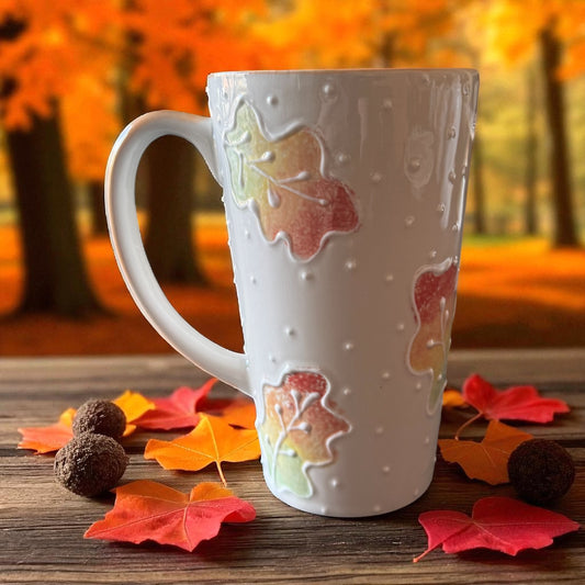 Fall painted mug with leaf designs on a wooden surface with autumn leaves and background - Ladybird Ceramics Original 