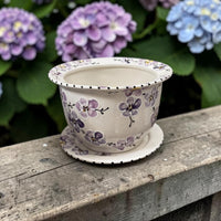 Ceramic flowerpot with purple cherry blossom floral design on a wooden surface with hydrangeas in the background | Ladybird Ceramics Canada